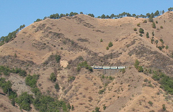 THE TOY TRAIN MANEUVERING THE RAILS AND THE TUNNELS
